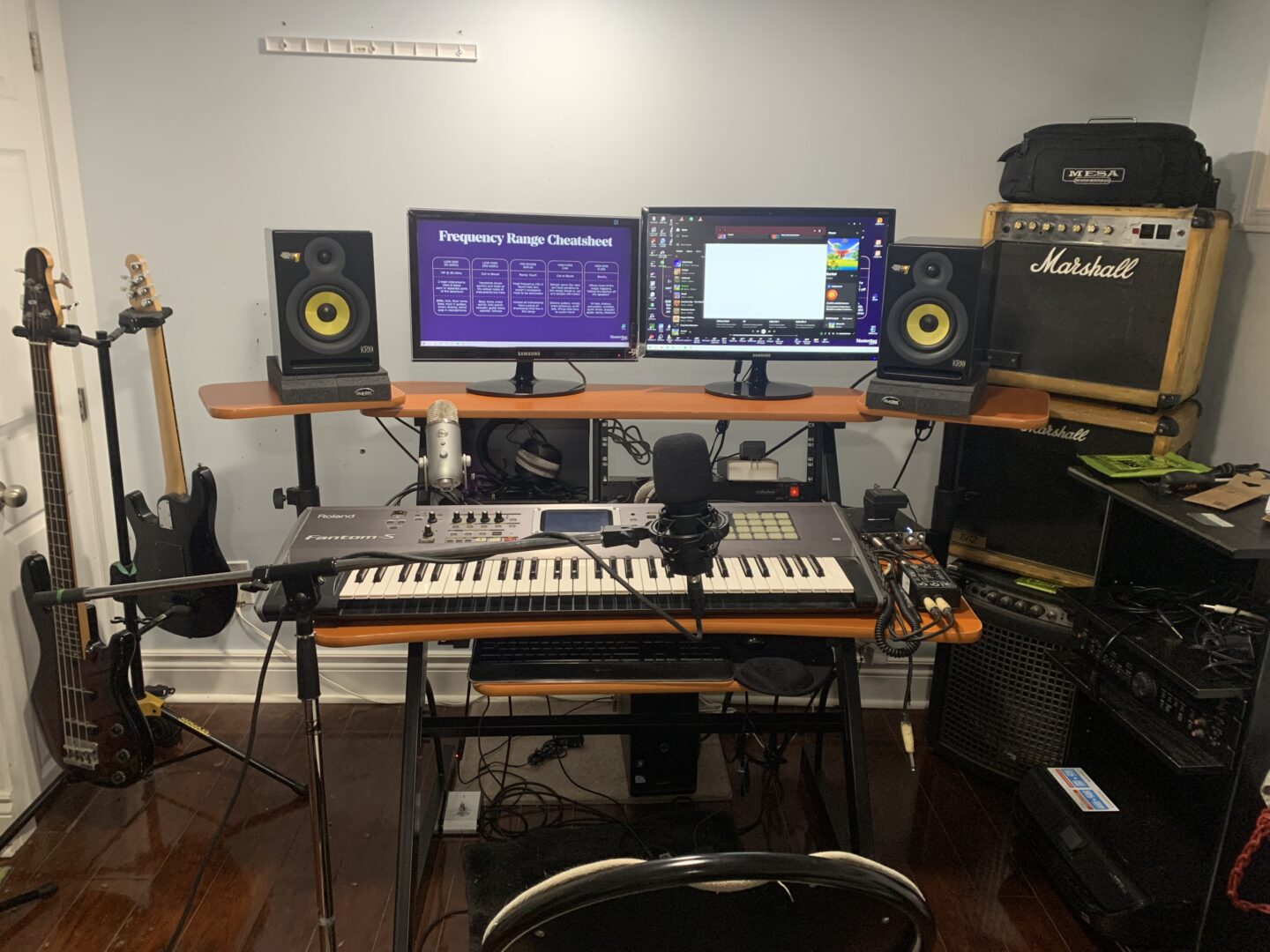 My desk, showing speakers and Roland keyboard, centred against the bare wall.